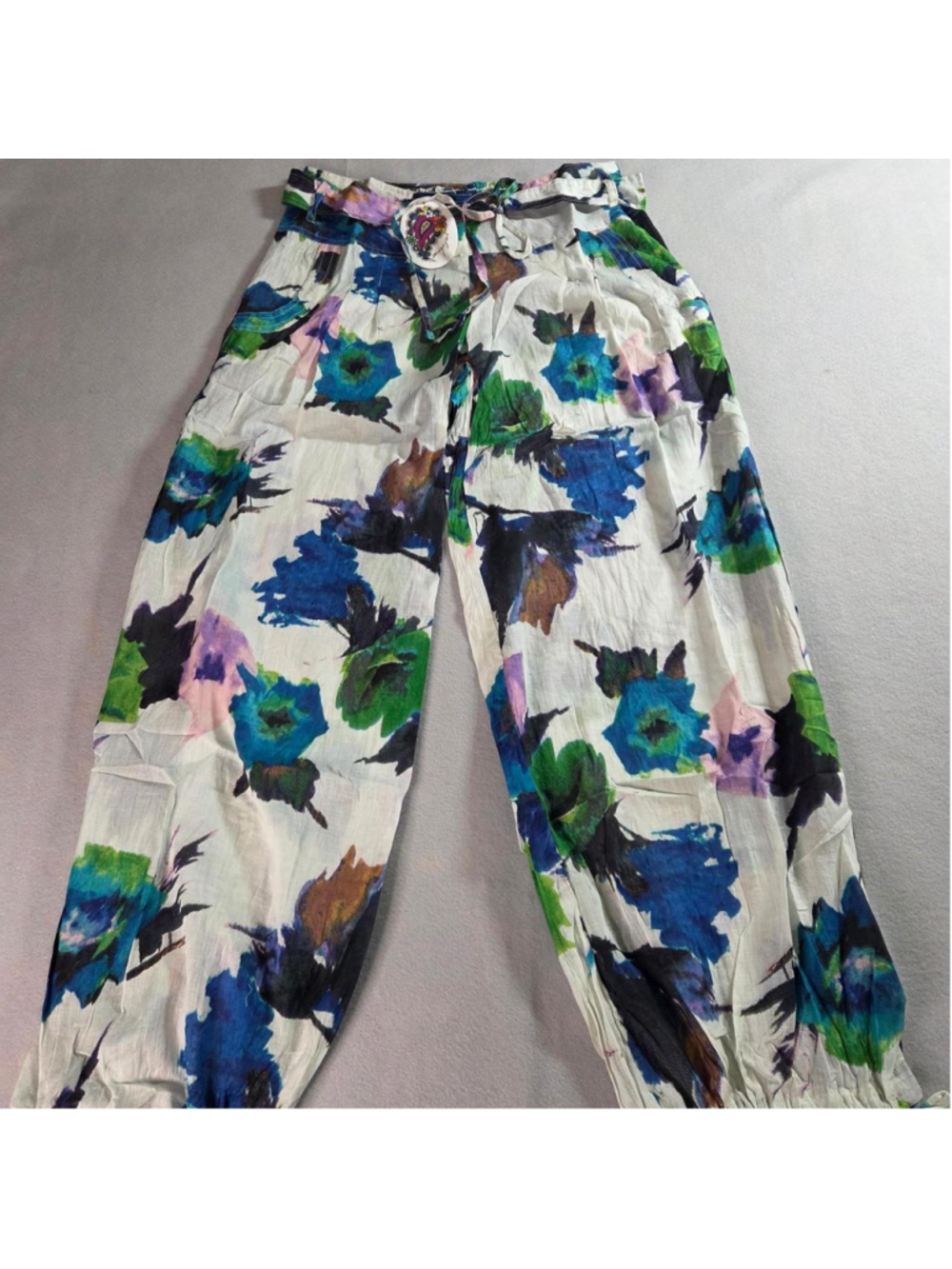 Magazine brand floral pants with blue, green, and purple flowers on a white back